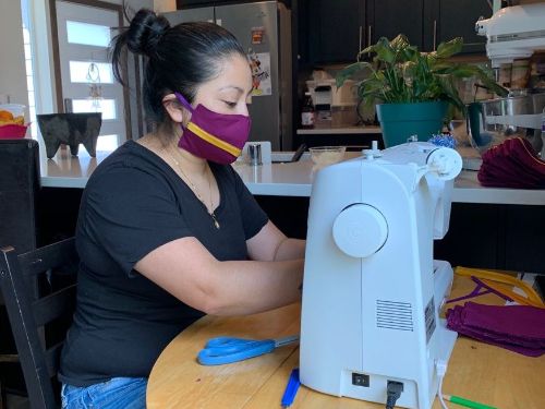 PLN participant sewing masks at her home.